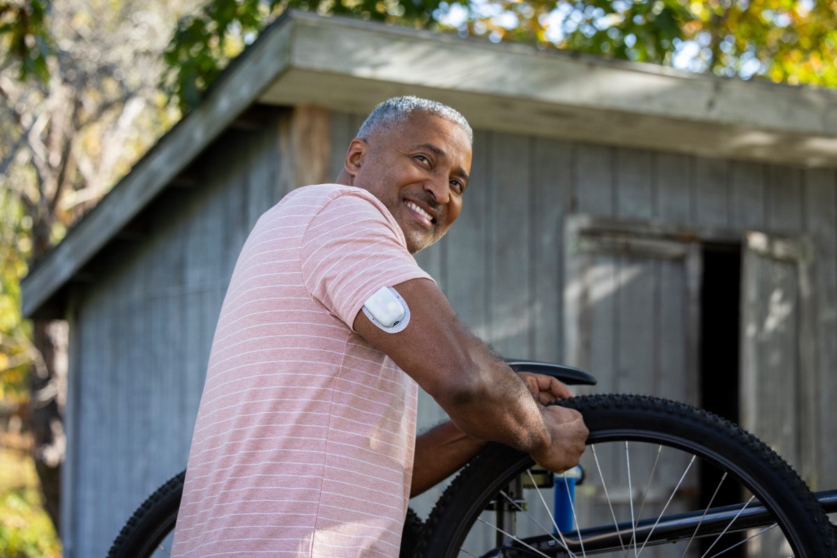Man working on his bicycle with Omnipod Pod on his right arm
