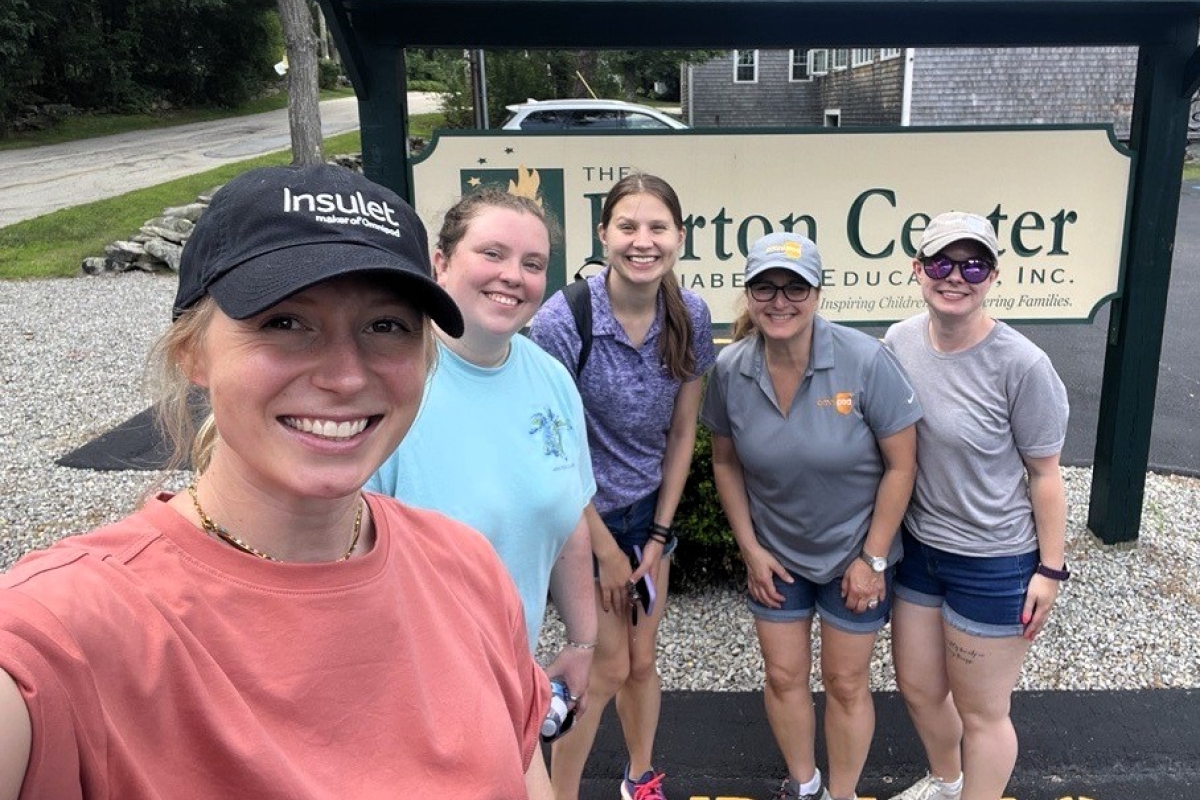 Insulet employees at Camp Barton in front of sign