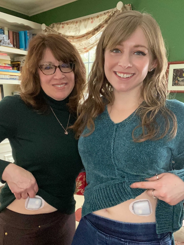 A mom and her daughter showing their wearable Omnipods