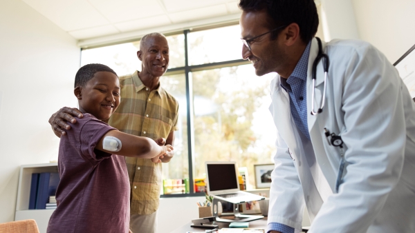 A young Podder shows his Omnipod to his doctor