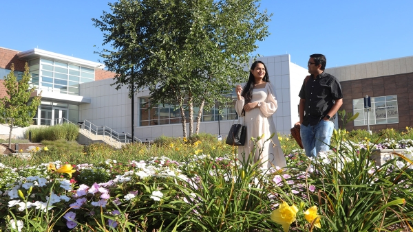 Two Insulet employees walking in a flower garden outside in the office