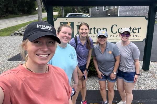 Insulet employees at Camp Barton in front of sign