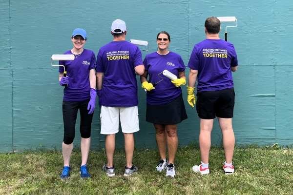Insulet employees painting a wall outside to help the community