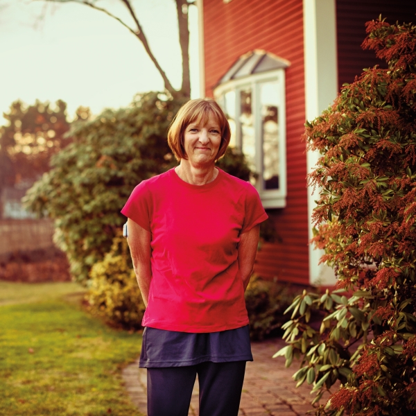 A woman smiling and posing in her yard